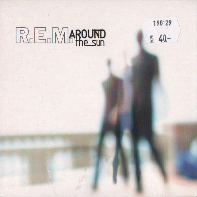 Album cover of R.E.M.'s 'Around the Sun' with blurred figures and text.