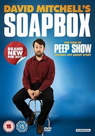 David Mitchell's Soapbox DVD cover featuring a seated man in a red shirt and black trousers against a blue gradient background, with large title text and age rating badges.