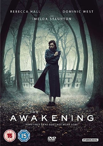 Movie poster for 'The Awakening' featuring a woman in a dark coat standing in a forest.